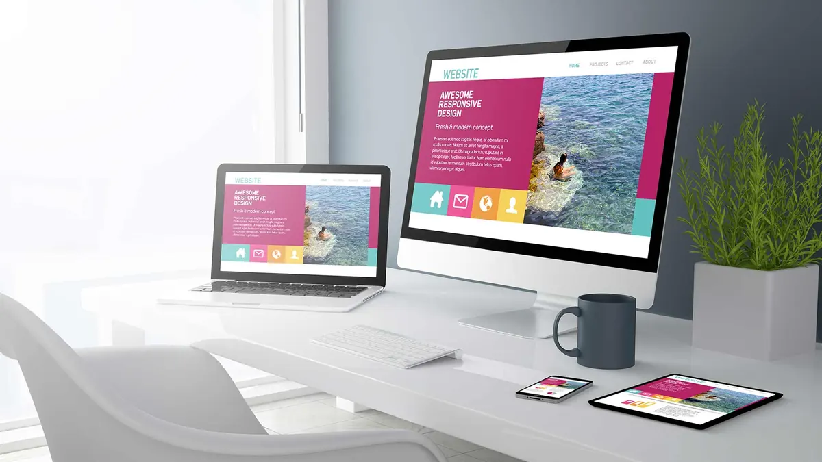 Escritorio con web responsive en monitor, portátil, tableta y móvil