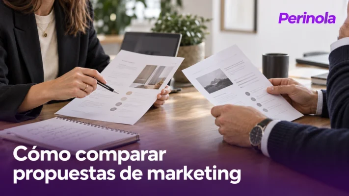 Dos personas revisan propuestas impresas en una mesa de trabajo.